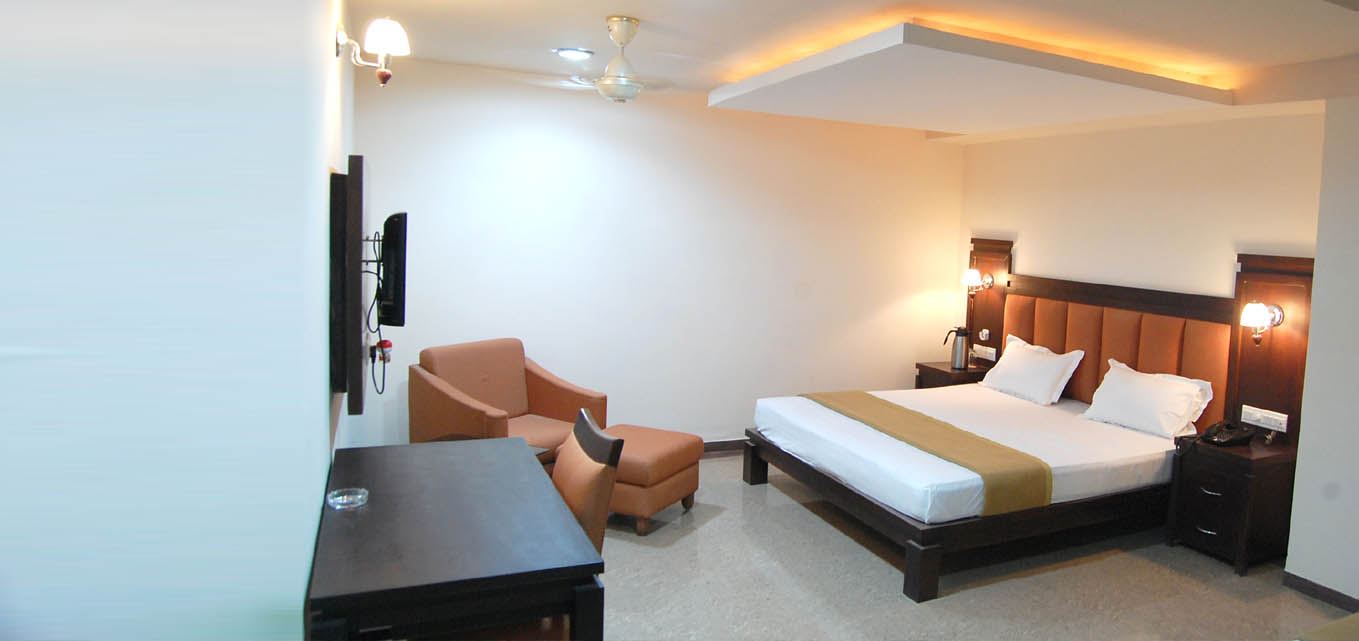 A Royal Suite with a seating area, coffee table and king bed.